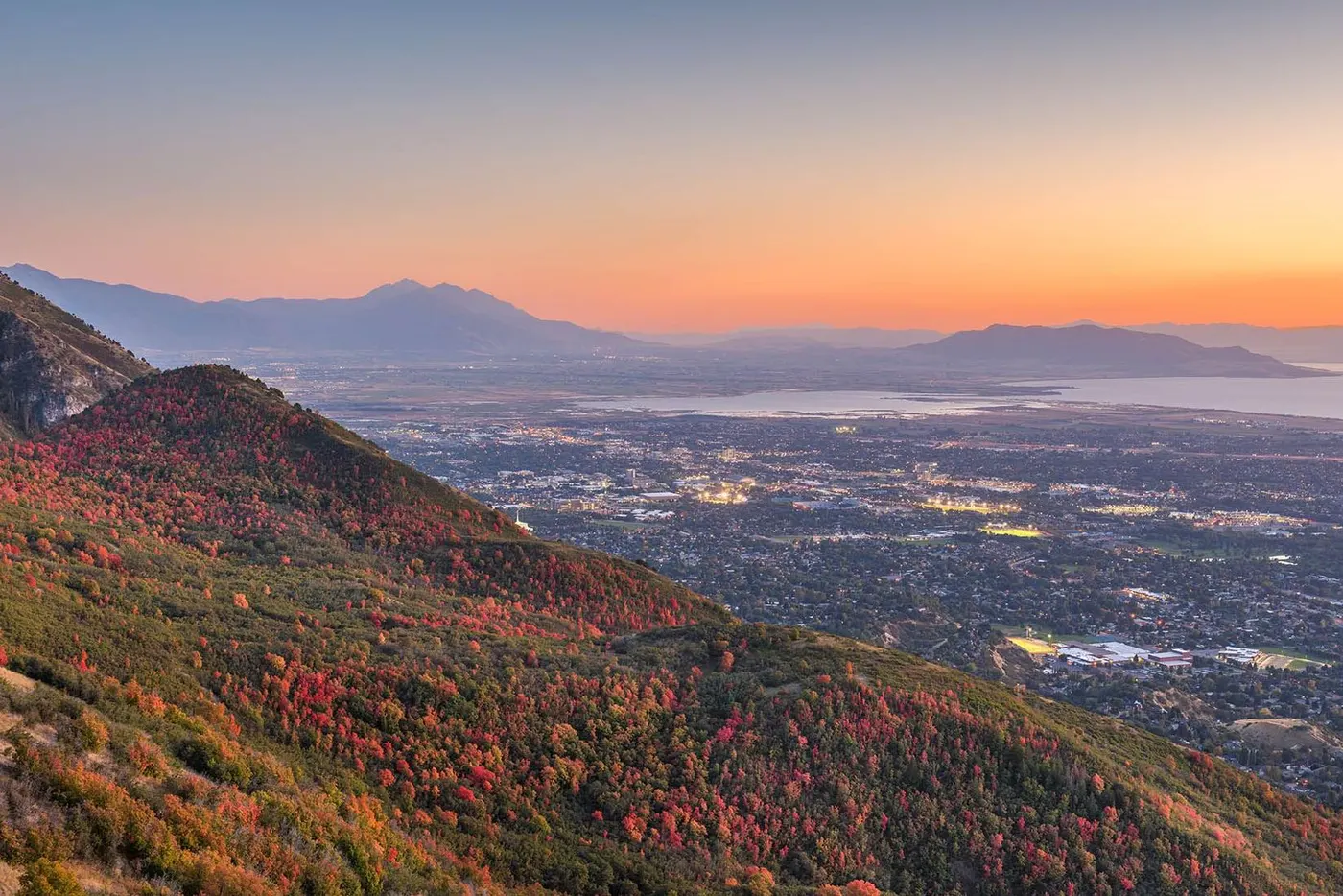 Autumn mountainside overlooking Salt Lake Valley at sunset with distant lake