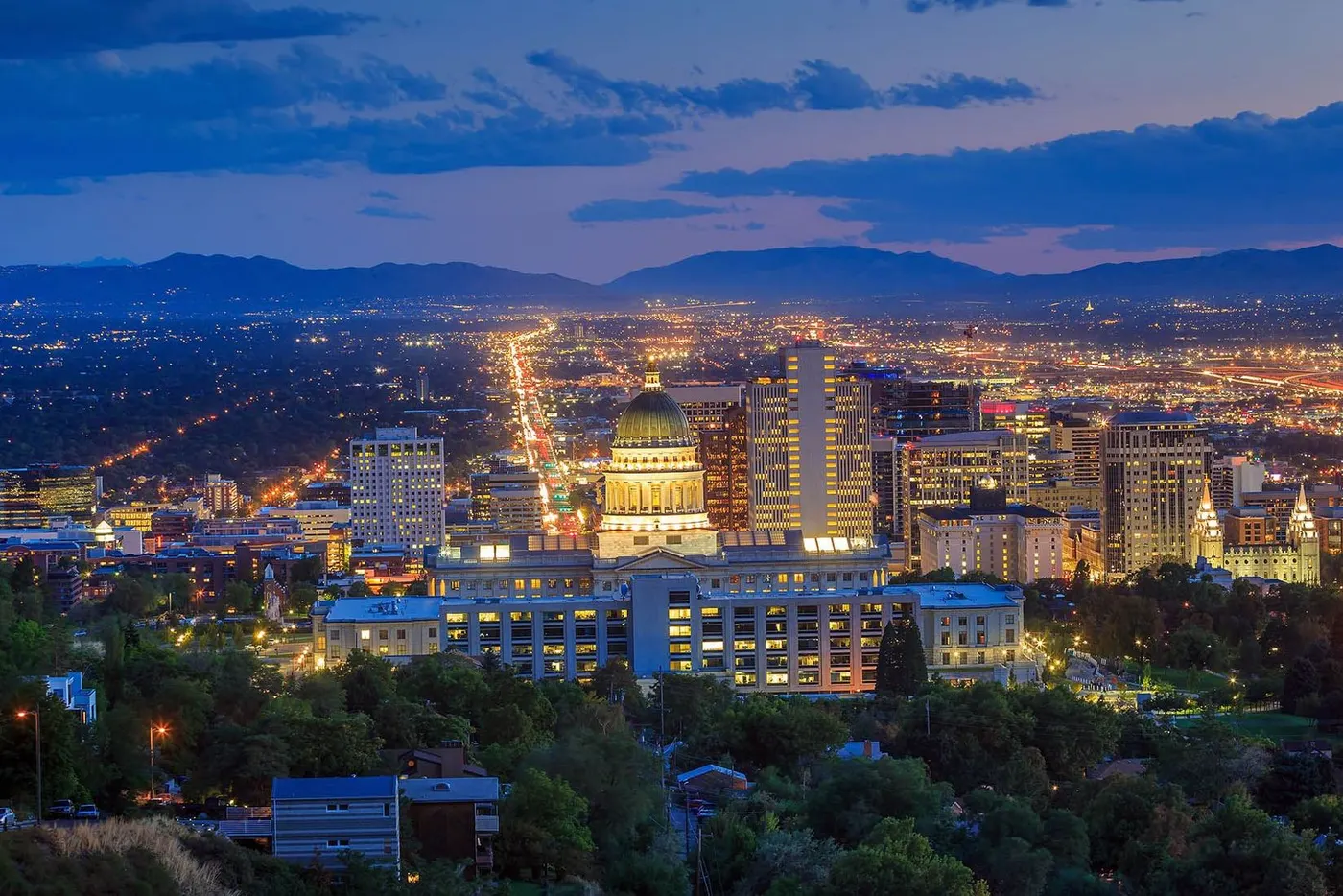 Salt Lake City skyline at dusk with Utah State Capitol and mountain backdrop
